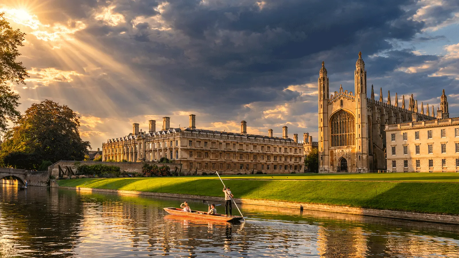 People punting on the River Cam as sun rays light up King’s College Chapel, Cambridge