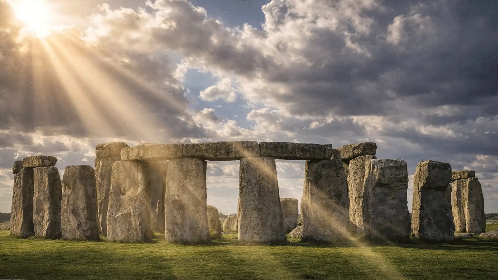 Sun rays over Stonehenge stone circle on Salisbury Plain under dramatic clouds