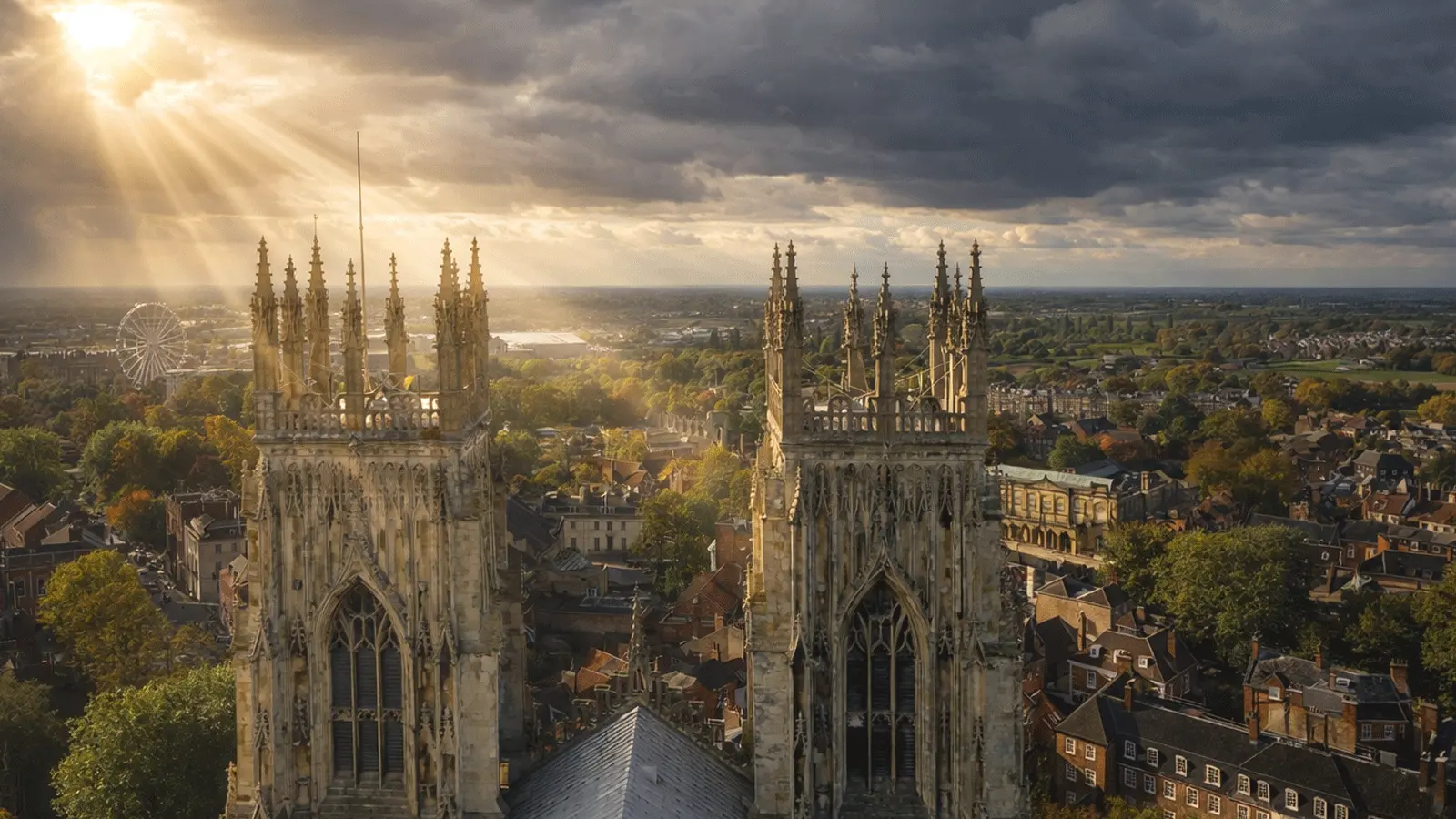 Sun rays over York Minster towers with a panoramic view of York city rooftops